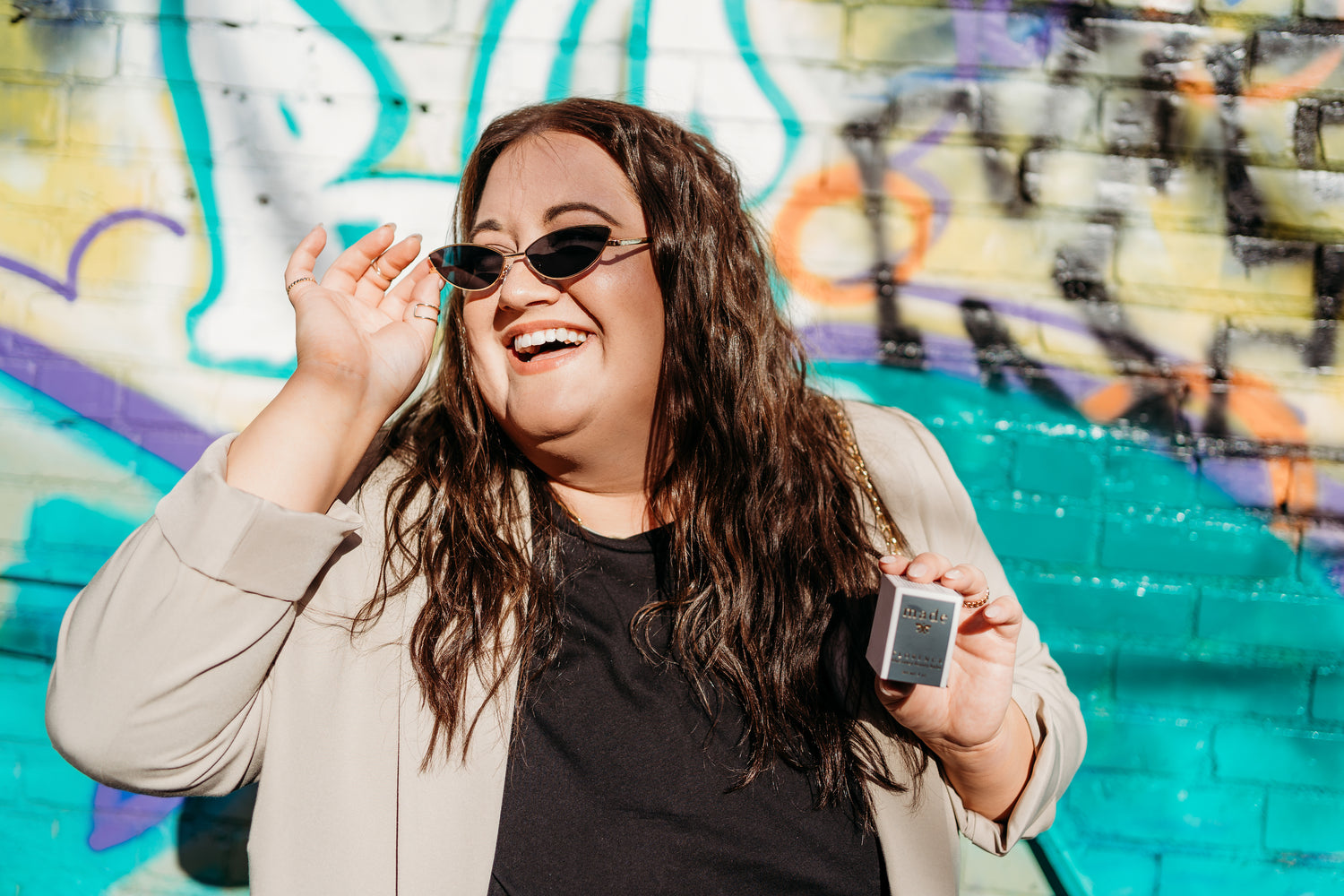 Best spas in Nashville photo with girl holding skincare product against wall.