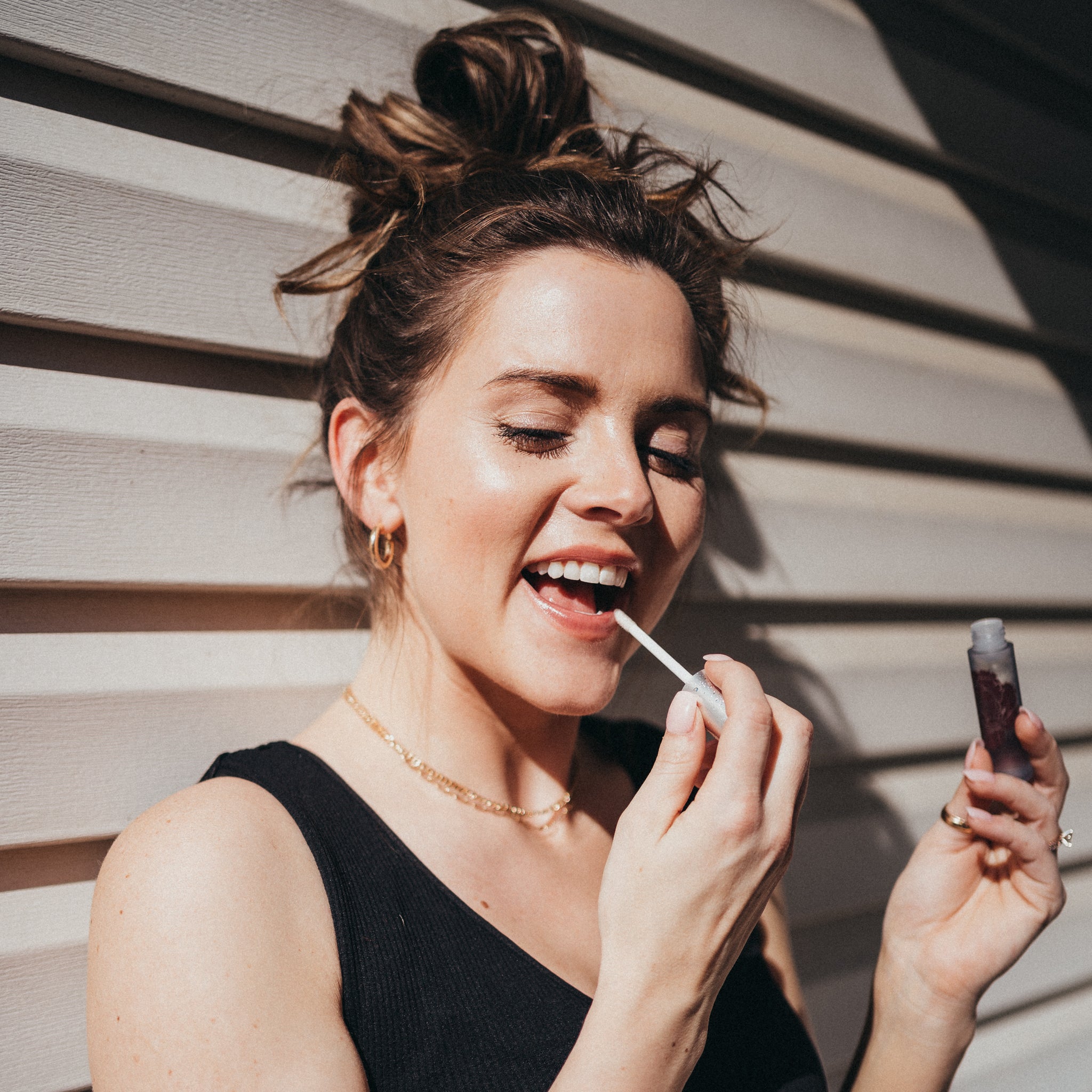 Clean beauty girl applying lip plump treatment for dry chapped lips.